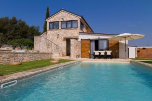 uma casa com piscina em frente a uma casa em Villa Royal with heated pool em Biograd na Moru