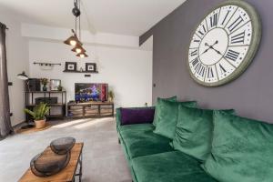 uma sala de estar com um sofá verde e um grande relógio em Villa Royal with heated pool em Biograd na Moru