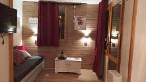 a small room with red curtains and a small table at PARADISKI-BELLE PLAGNE, Altitude 2050m, APPART skis aux pieds 4 personnes in La Plagne Tarentaise