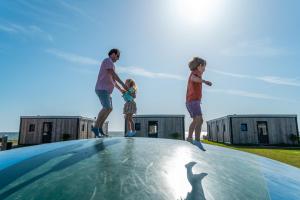 a man and two boys standing on top of a trampoline at EuroParcs Enkhuizer Strand in Enkhuizen