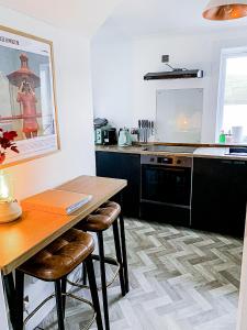 a kitchen with a wooden table with two stools at This must be the place - Skye, Carbost in Carbost