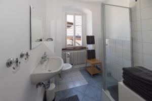 a white bathroom with a sink and a shower at Gutsverwaltung Schloss Eyrichshof in Ebern