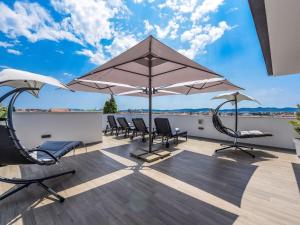 a patio with chairs and umbrellas on a roof at Rooftop heated pool Villa Jelena in Zadar