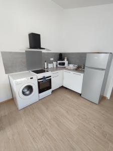 a kitchen with a washing machine and a refrigerator at Paisible maisonnette à Entraigues sur la Sorgue in Entraigues-sur-la-Sorgue