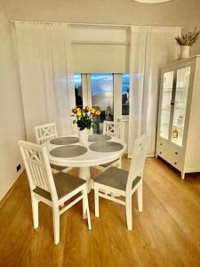 a white table and chairs in a room with a window at Keskuse apartment with a balcony in Haapsalu