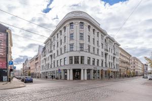 a large white building on a city street at Library House "Bibliotekas nams" - Apartment with Park View in Riga