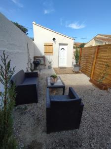 a patio with two couches and a table and a building at Paisible maisonnette à Entraigues sur la Sorgue in Entraigues-sur-la-Sorgue