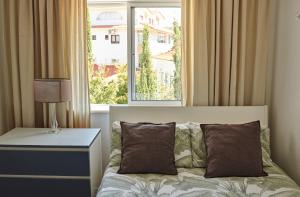a bedroom with a bed with a large window at Ljmonade Hostel in Cascais +93 photos