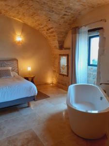 a bedroom with a bed and a bath tub at coeur de famille in Bessas