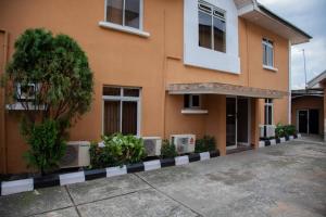 a orange building with two windows and a tree at TRENDY INN LTD in Lagos
