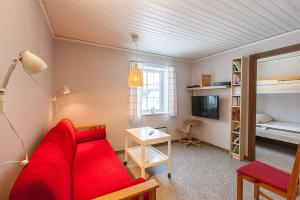 sala de estar con sofá rojo y cama en Lullens Stugby - Lägenhetshuset 6-9 en Bruksvallarna
