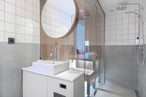 un bagno bianco con lavandino e specchio di Quality Hotel Globe a Stoccolma