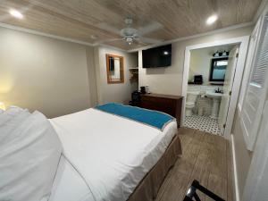 a bedroom with a large bed and a bathroom at Seashell Motel and International Hostel in Key West