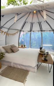 Bett in einem Zimmer mit einem großen Fenster in der Unterkunft Eco Lung Hotel in Montezuma