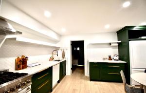 a kitchen with green cabinets and white counter tops at Be Our Gaston's A Walk in the Park in Savannah +23 photos