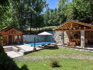 a backyard with a swimming pool and a house at Luxury Chalet Regina in Bruvno