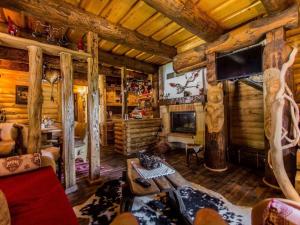 una sala de estar en una cabaña de madera con mesa y TV en Luxury Chalet Regina, en Bruvno