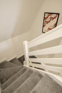 a stairway with a white rail and a picture at Newly Renovated Central One-Bedroom, 99 Steps to the Sea in Brighton & Hove