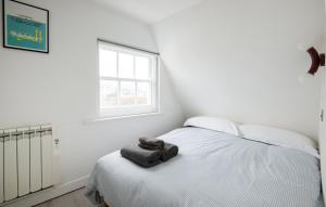 a white bedroom with a bed and a window at Newly Renovated Central One-Bedroom, 99 Steps to the Sea in Brighton & Hove