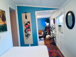 a bedroom with a white bed and a blue wall at Boho-Chic Studio - Unit 1 in Bloomington