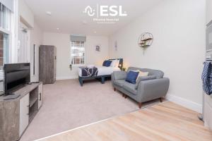 Una sala de estar con una cama, un sofá y un televisor. en Studio 1, First Floor Town Centre Apartment, en Shrewsbury 4 fotos más