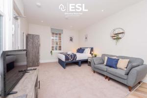 Un dormitorio con una cama, un sofá y un televisor. en Studio 1, First Floor Town Centre Apartment, en Shrewsbury