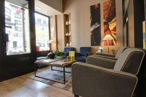 a living room with couches and chairs and a table at Hôtel Cecyl Reims Centre in Reims +51 photos