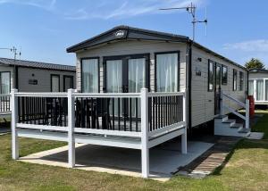 a tiny house with a white fence in a yard at Willows Holiday Park in Withernsea