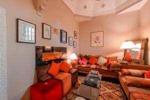 uma sala de estar com um sofá e uma mesa em Abelia Traditional Riad - All Inclusive - 2023 traveler's Choice Award em Marraquexe
