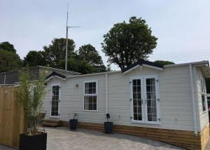 a white house with windows and a fence at Stream Valley Holiday Park in Penzance