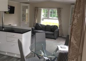a living room with a glass table and a couch at Stream Valley Holiday Park in Penzance