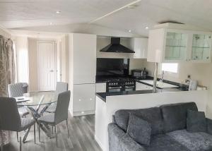 a kitchen and living room with a couch and a table at Stream Valley Holiday Park in Penzance