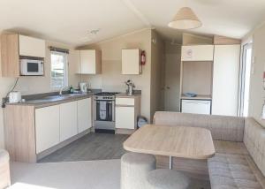 a kitchen and living room with a couch and a table at St Cyrus Park in Montrose