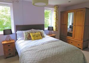 a bedroom with a bed with two lamps and a dresser at Kingswood Golf Lodges in Thorne