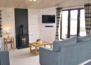 a living room with a couch and a fireplace at Wighill Manor Lodges in Newton Kyme