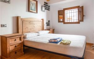 1 dormitorio con 1 cama con cabecero de madera y ventana en 2 Bedroom Beautiful Home In Montalbn en Montalbán