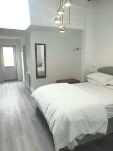 ein weißes Schlafzimmer mit einem großen Bett und einem Spiegel in der Unterkunft The Bay Studio 2 - Broadstairs in Broadstairs