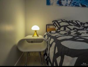 巴紐的住宿－Magnificent One Bed Room Appartement with Terrasse Options, Parking and Air conditionner，一间卧室配有一张床和一张桌子上的台灯