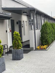 un edificio con arbustos y flores delante de él en Hostel Adabet en Kępno