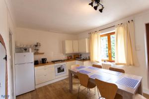 a kitchen with a table and a white refrigerator and a table and chairs at House - Sleeps 6 - Parking - Garden in Brécé
