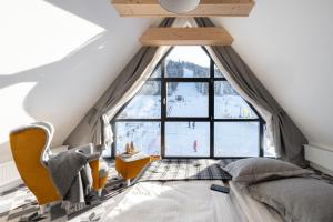 ein Schlafzimmer mit einem Bett und einem großen Fenster in der Unterkunft Apartamenty Pod Stokiem Nosal Zakopane in Zakopane