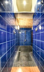 bagno con piastrelle blu e doccia. di Scuderie Il Magnifico a Firenze