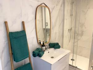 ein Bad mit einem Waschbecken und einem Spiegel in der Unterkunft La Topaze - Etretat in Étretat