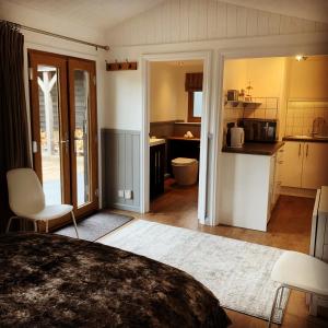 a bedroom with a bed and a kitchen at Hascombe Accommodation in Hascombe