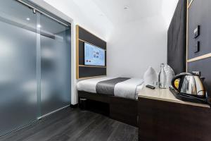 une chambre d'hôtel avec un lit et une douche dans l'établissement The Z Hotel Trafalgar, à Londres