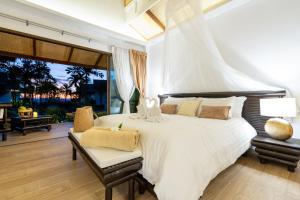 ein Schlafzimmer mit einem großen weißen Bett und einer Terrasse in der Unterkunft Lanta Palace Beach Resort & Spa - Adult Only in Ko Lanta