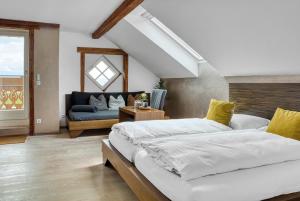 a bedroom with two beds and a blue couch at GIRLINGGUT Schlafen Starten Salzburg in Elixhausen