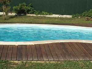 a pool with a wooden deck in a yard at Casas Zé Pinto in Hospital