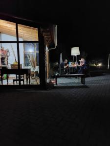 two people sitting on a bench at night at Casas Zé Pinto in Hospital