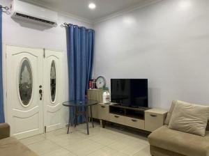 a living room with a couch and a table and a tv at Rumah Putih Homestay (RPH) in Malacca